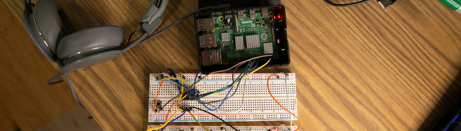 Raspberry pi in a case beside a breadboard